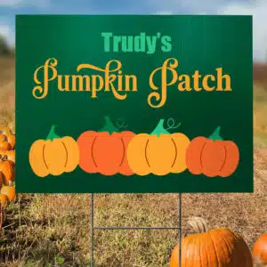 Custom printed coroplast yard sign for "Trudy's Pumpkin Patch" displayed in an autumn field.
